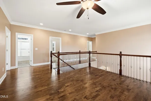 a view of a hallway with wooden floor and staircase