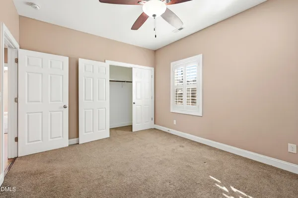 an empty room with closet and windows