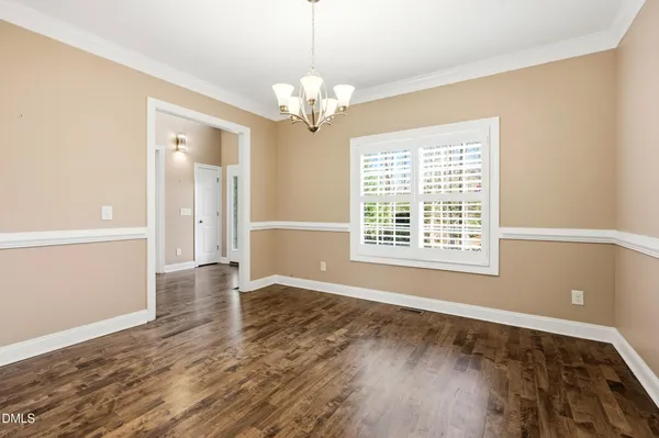 a view of a hallway with wooden floor and a chandelier
