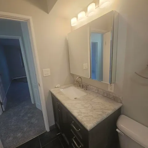 a bathroom with a granite countertop sink and a mirror