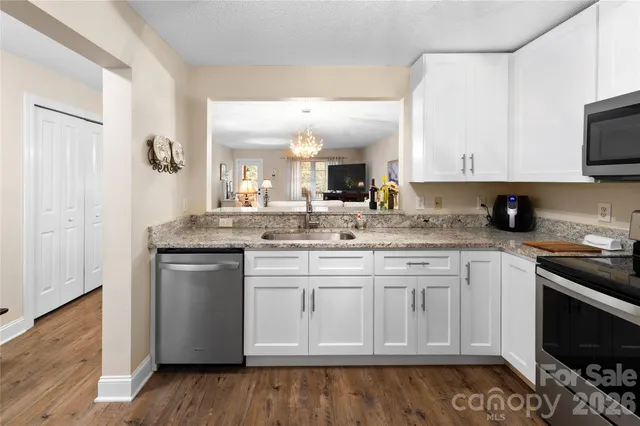 a kitchen with granite countertop a sink stove and cabinets