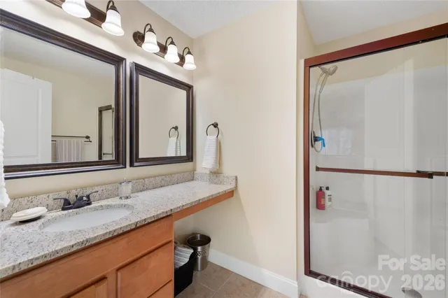 a bathroom with a granite countertop sink mirror and a shower