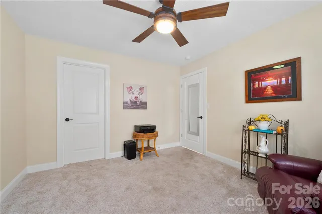 a view of a workspace with furniture and a ceiling fan