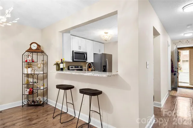 a kitchen with stainless steel appliances kitchen island a refrigerator and a wooden floor