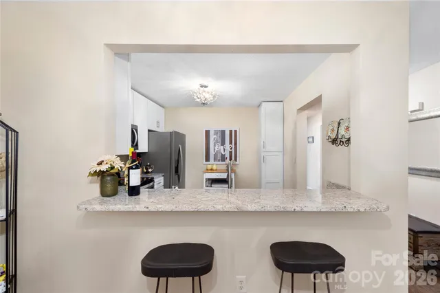 a kitchen with stainless steel appliances granite countertop a sink and a refrigerator