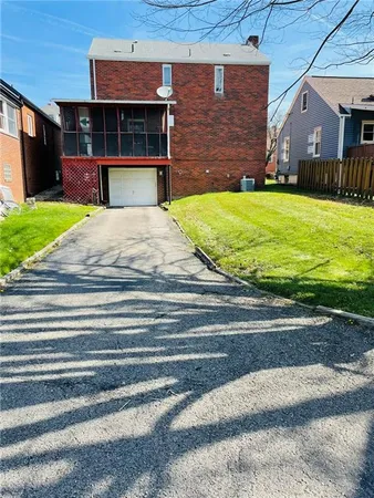 a view of a house with a yard and a garage
