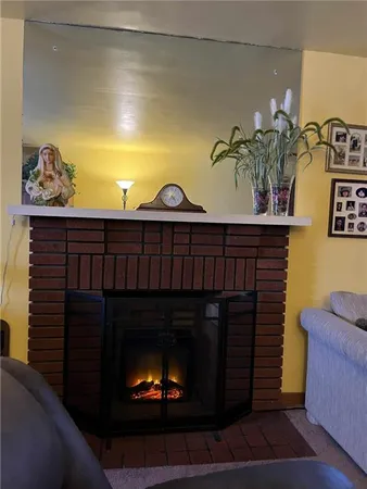 a fireplace with vase and flowers on it