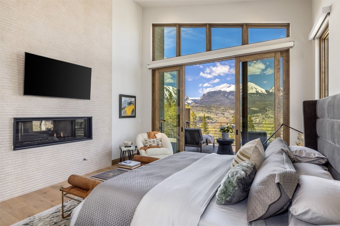 194 Angler Mountain Ranch Road Silverthorne, CO 80498 - Photo 20 of 50 a bed sitting in a bedroom next to a large window with a flat screen tv