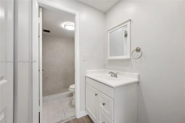 a bathroom with a sink toilet and shower
