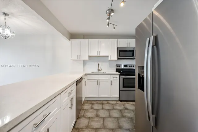 a kitchen with stainless steel appliances granite countertop a refrigerator sink and stove