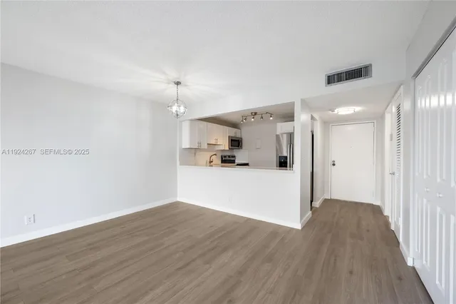 a view of a refrigerator in kitchen and wooden floor