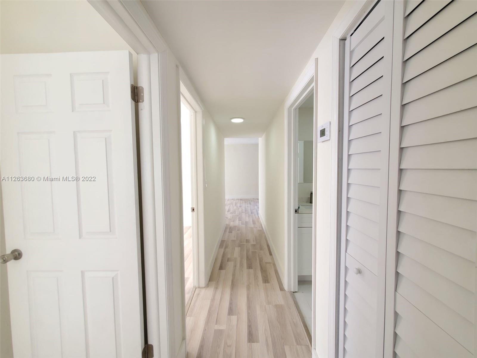291 West 41st Street Hialeah, FL 33012 - Photo 14 of 40 a view of a hallway with wooden floor and closet area