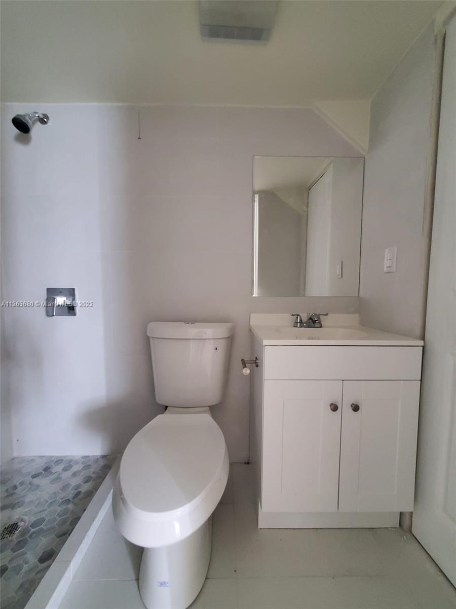 291 West 41st Street Hialeah, FL 33012 - Photo 23 of 40 a bathroom with a toilet sink and mirror
