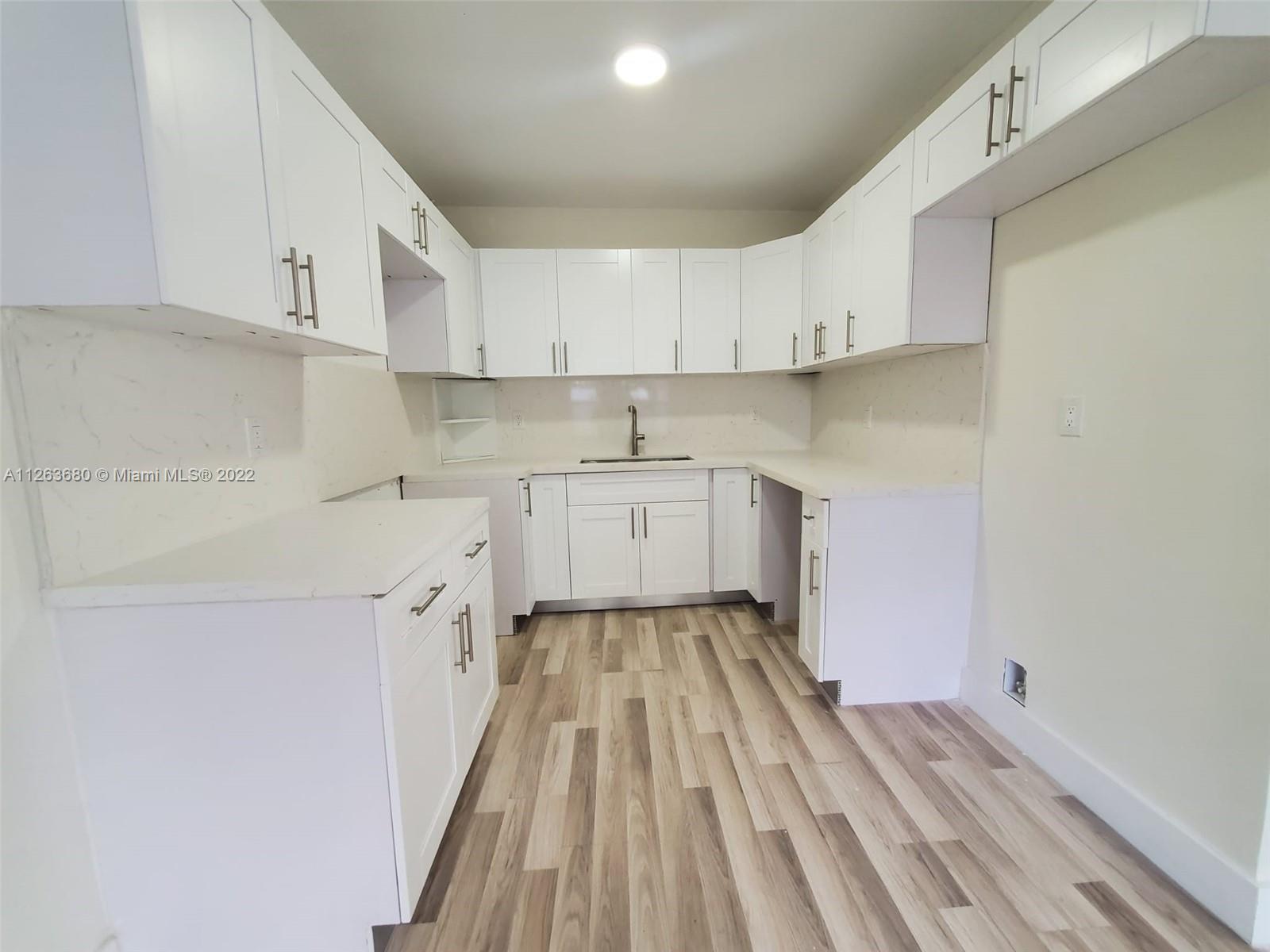 291 West 41st Street Hialeah, FL 33012 - Photo 33 of 40 a kitchen with a sink a stove and cabinets