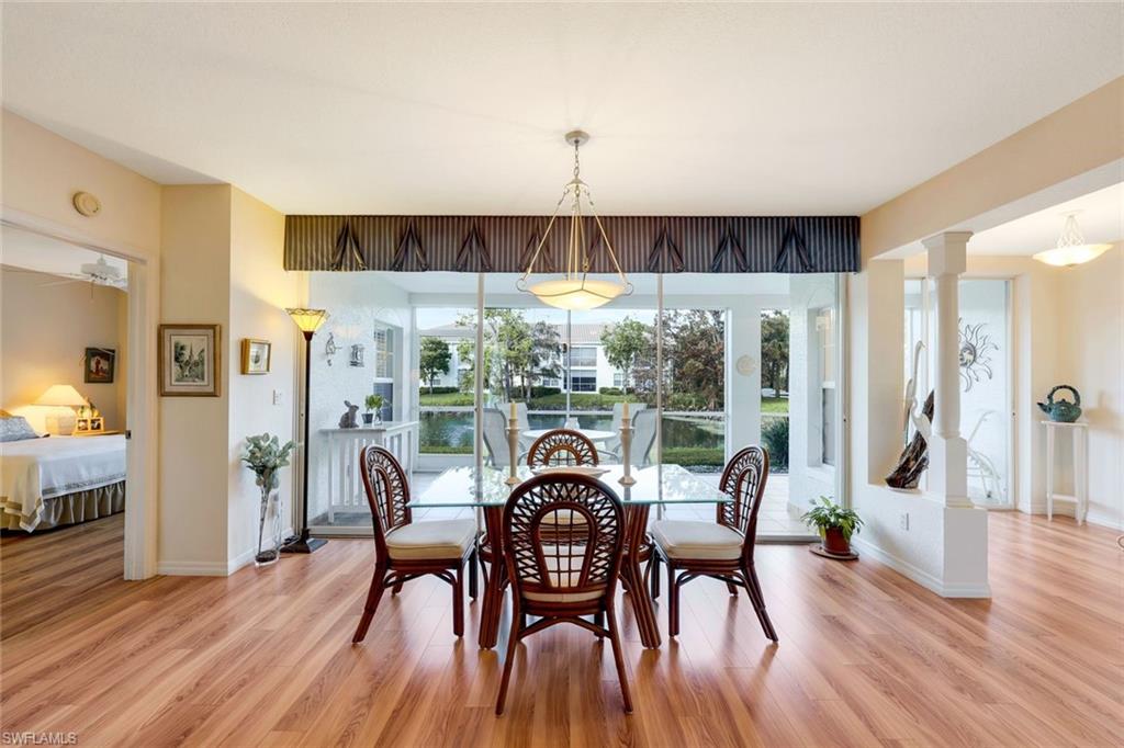 6891 Rain Lily Road, Unit 102 Naples, FL 34109 - Photo 8 of 33 Dining area with decorative columns, ceiling fan, and light hardwood / wood-style floors