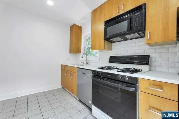a kitchen with stainless steel appliances a stove microwave and cabinets