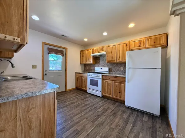 a kitchen with a refrigerator and a stove top oven