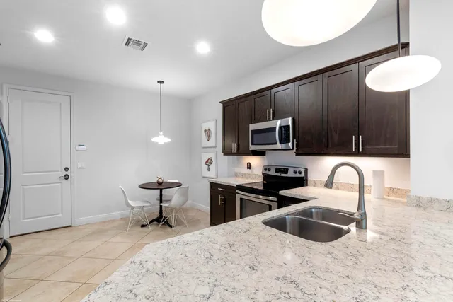 a kitchen with stainless steel appliances a stove a sink and a microwave