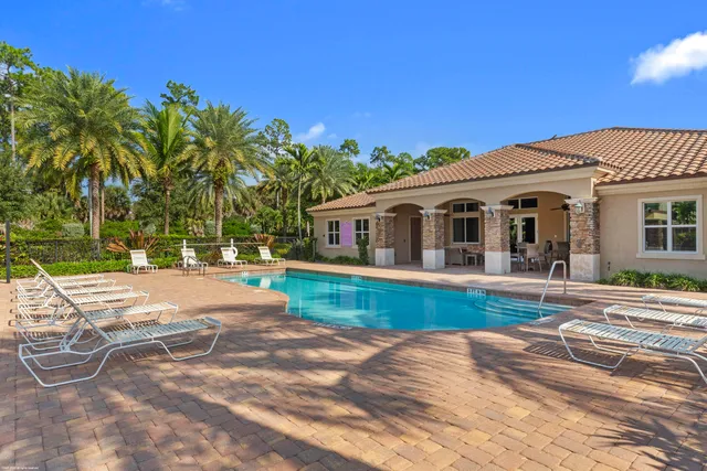 a view of a swimming pool with a patio and a yard