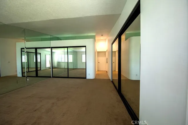 an empty room with large windows and stairs