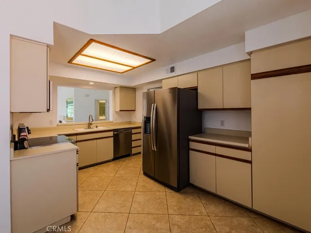 a kitchen with a refrigerator sink and cabinets