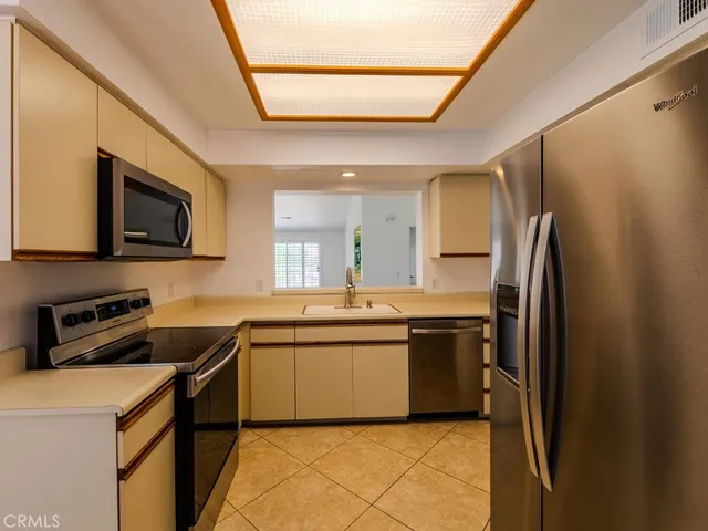 a kitchen with stainless steel appliances granite countertop a sink stove microwave and refrigerator