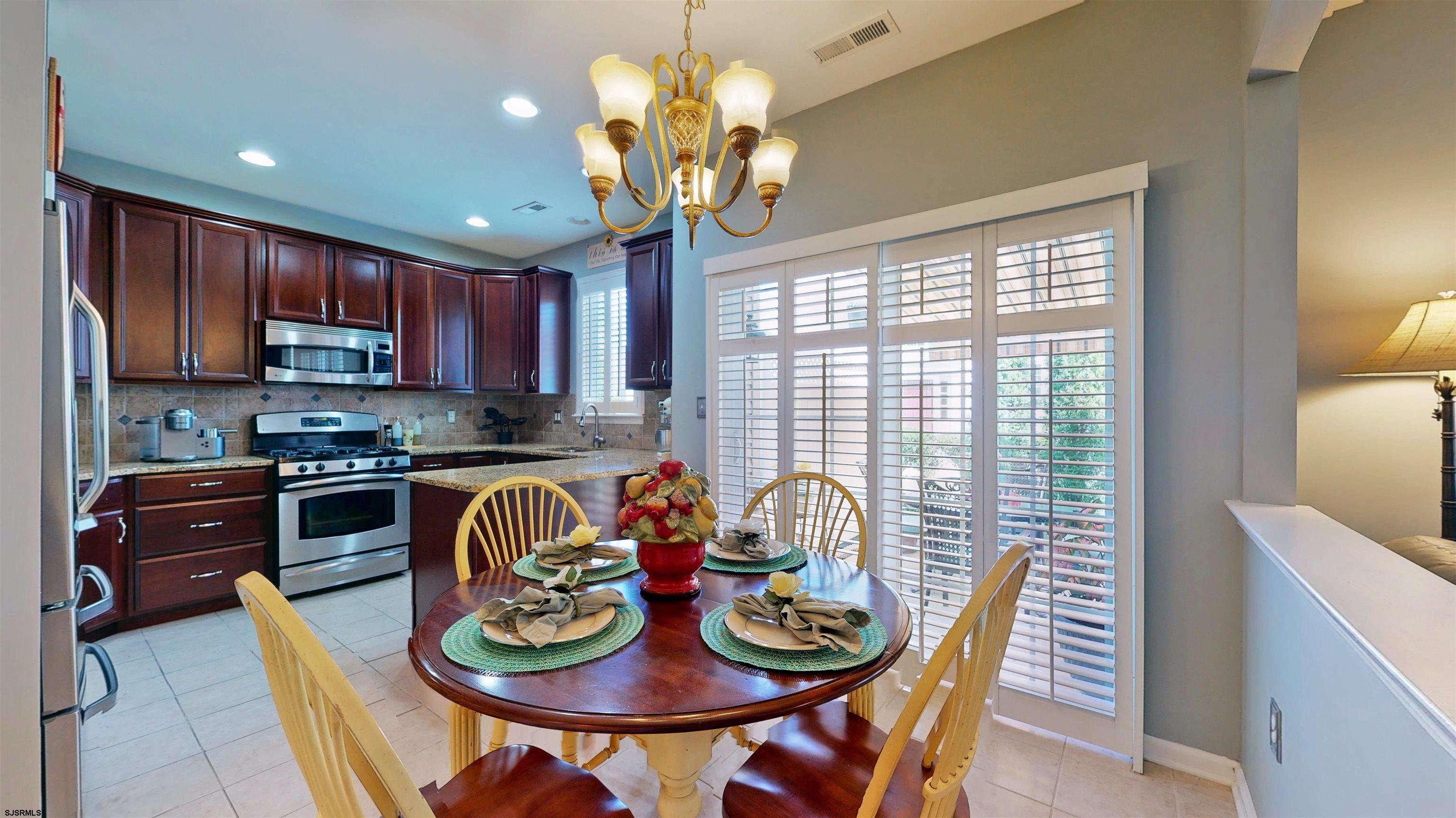 62 Ables Run Drive Absecon, NJ 08201 - Photo 11 of 38 a view of a dining room with furniture a chandelier and kitchen view