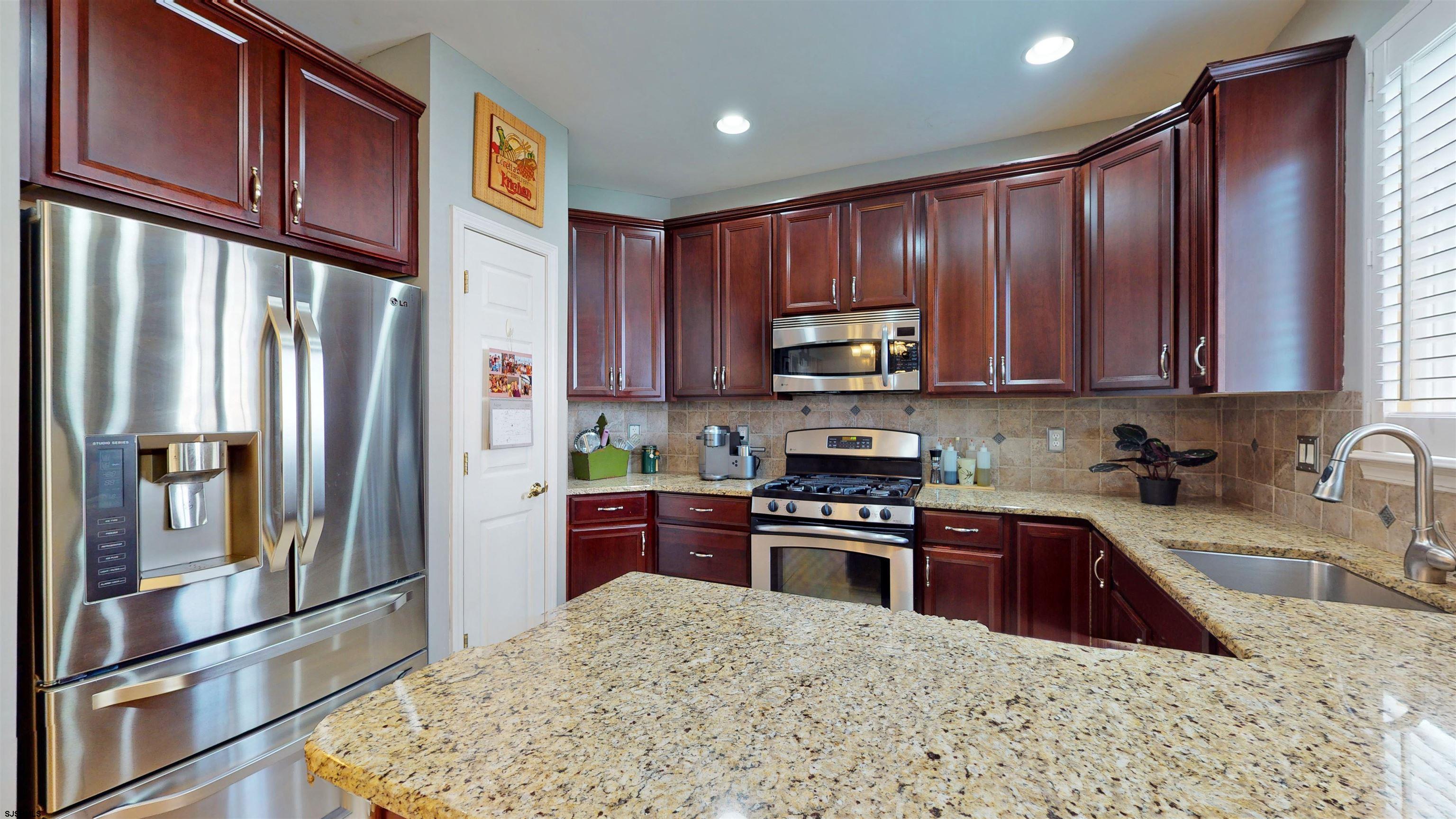 62 Ables Run Drive Absecon, NJ 08201 - Photo 13 of 38 a kitchen with stainless steel appliances granite countertop a refrigerator stove top oven a sink and dishwasher