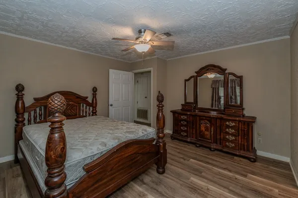 a bedroom with a bed a dresser and potted plants