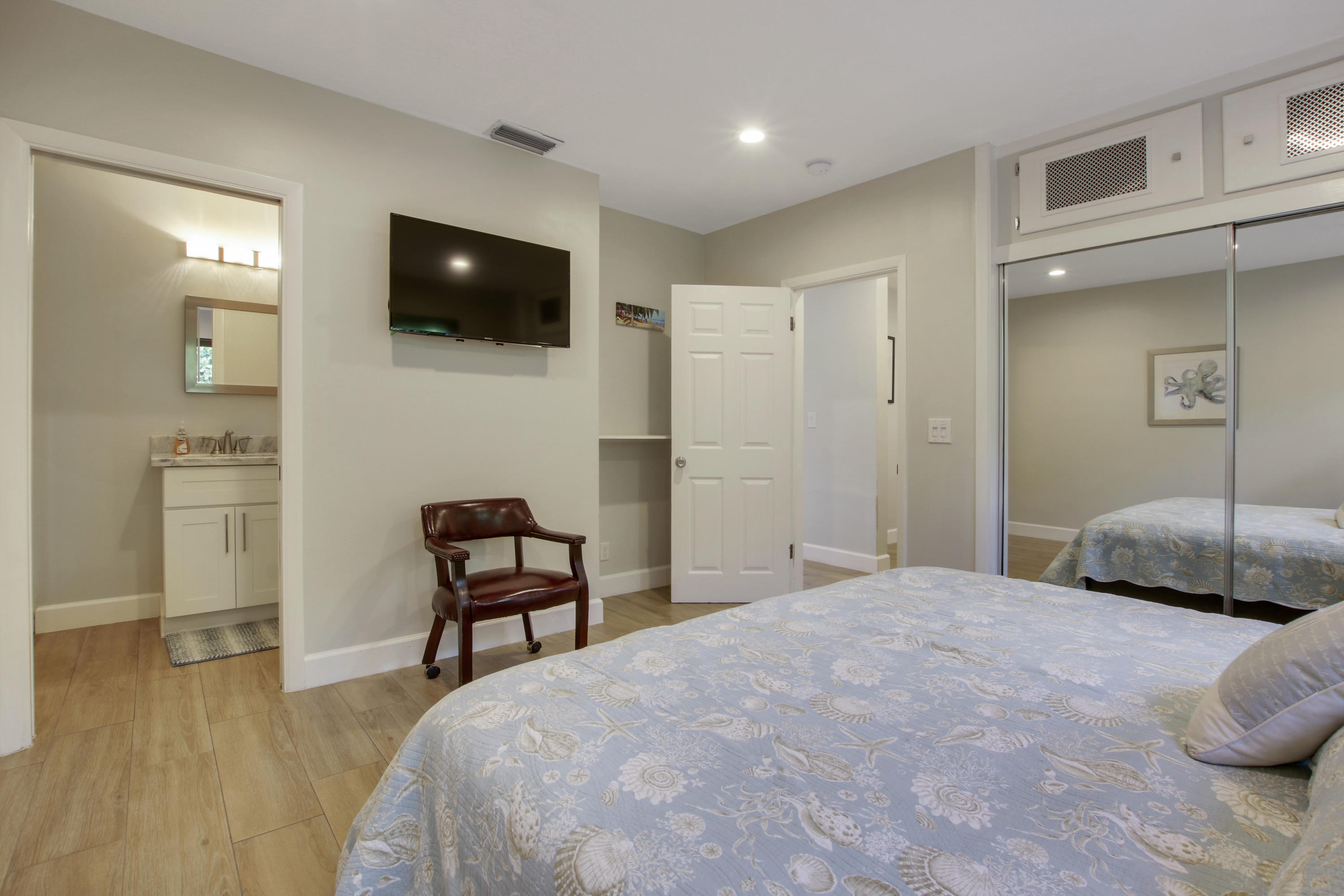 380 North Juno Lane Juno Beach, FL 33408 - Photo 17 of 22 a bedroom with a bed a television and wooden floor