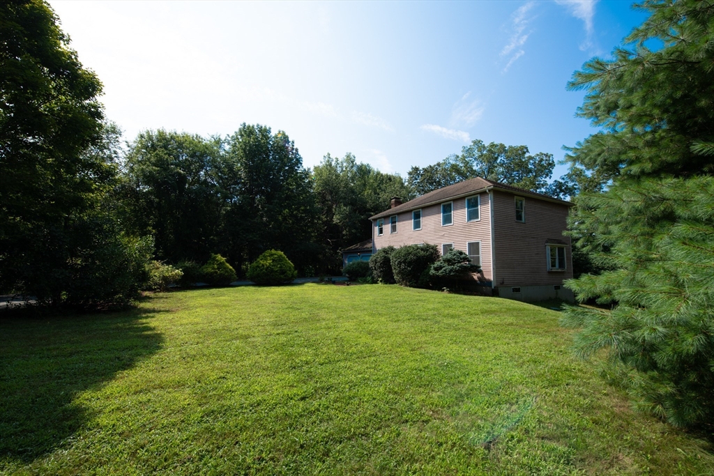 110 Mendon Road Northbridge, MA 01534 - Photo 2 of 37 a yellow house sitting in middle of the middle of a field