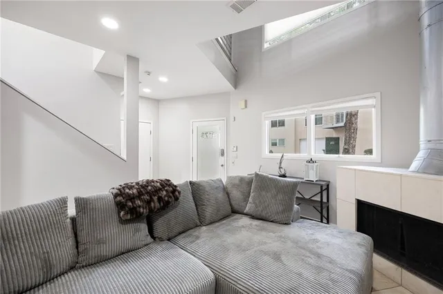 a living room with furniture a fireplace and a large window