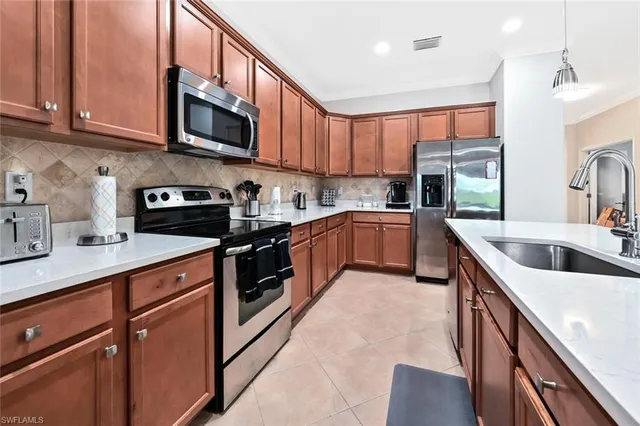 a kitchen with stainless steel appliances granite countertop a sink a stove top oven a counter space and cabinets
