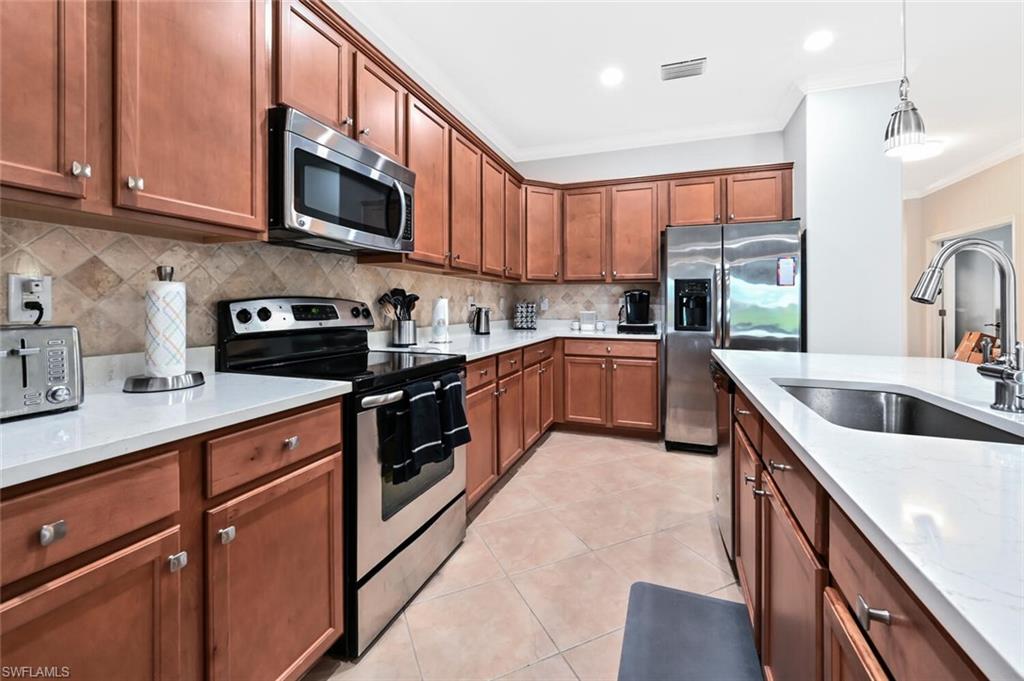 3742 Treasure Cove Circle Naples, FL 34114 - Photo 9 of 22 a kitchen with stainless steel appliances granite countertop a sink a stove top oven a counter space and cabinets