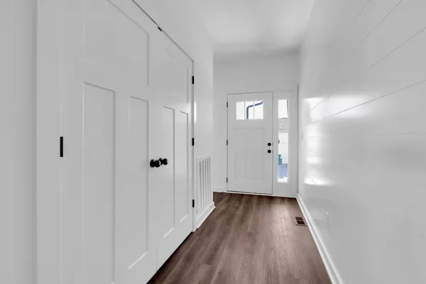 a very nice looking room with a large window wooden floor and a kitchen view