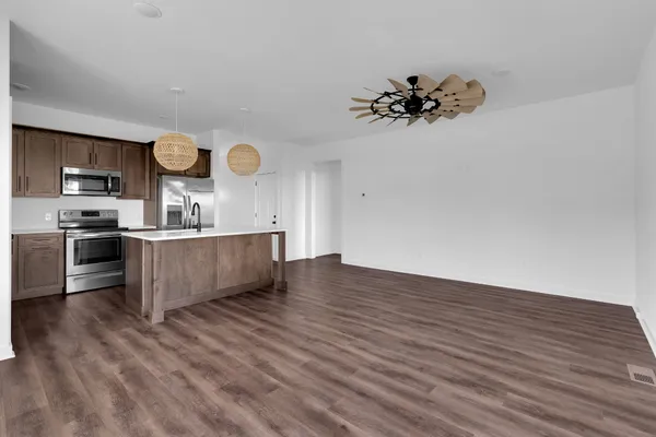a kitchen with kitchen island granite countertop a sink a stove and wooden floors