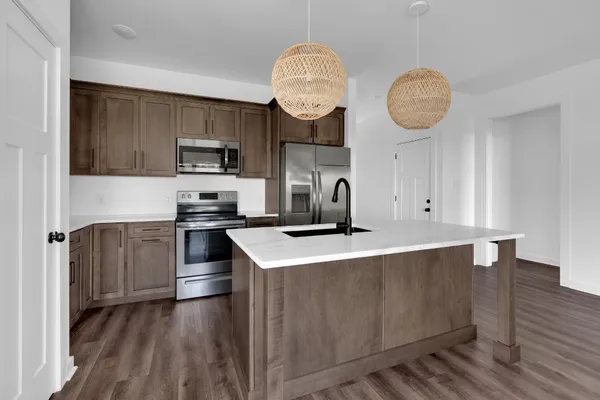 a kitchen with stainless steel appliances granite countertop a sink a stove and refrigerator