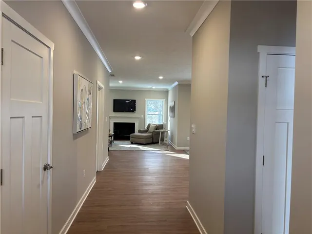 a view of a hallway with wooden floor living room and dining room