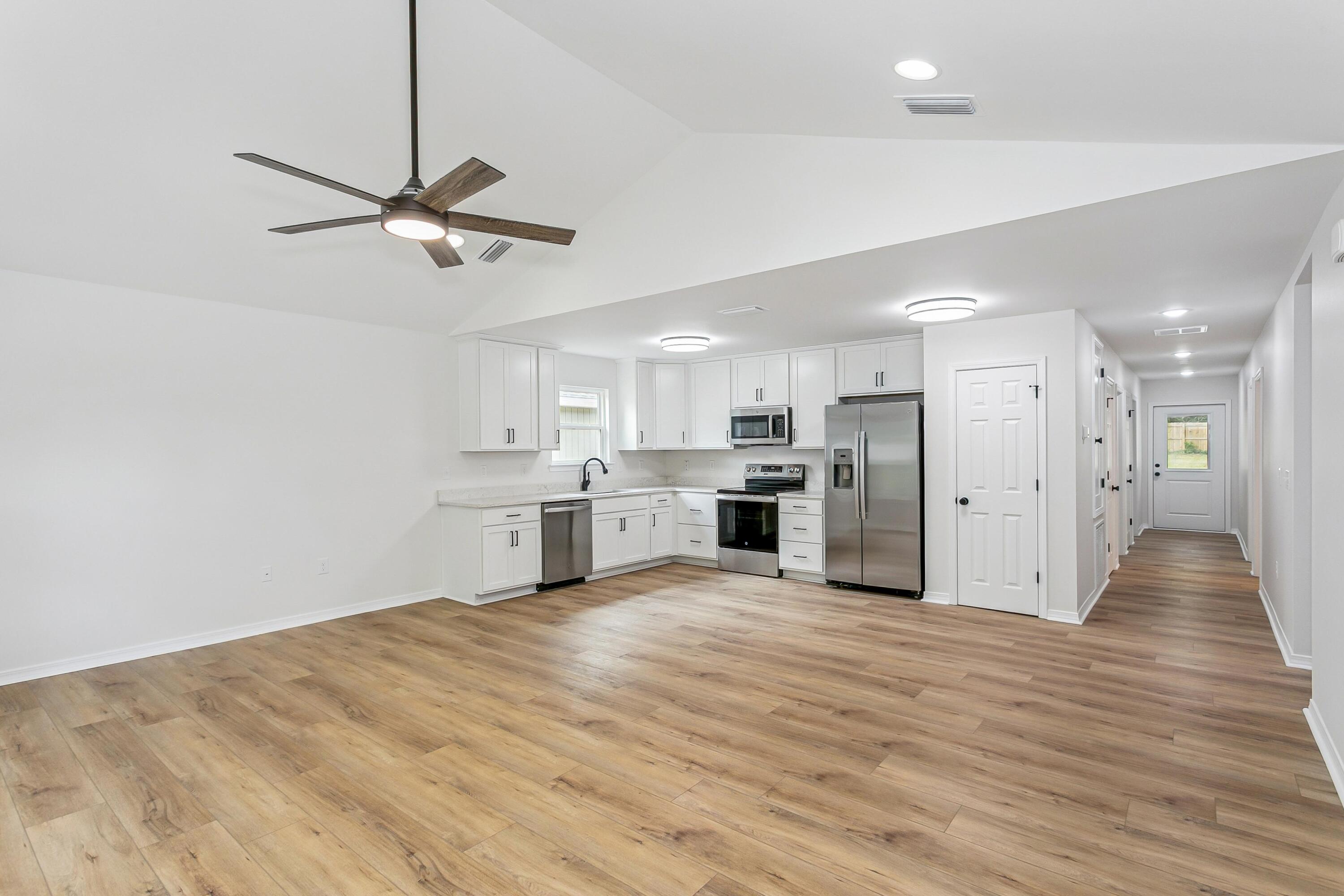 8086 3rd Street Laurel Hill, FL 32567 - Photo 8 of 35 a view of a kitchen with wooden floor and a kitchen space