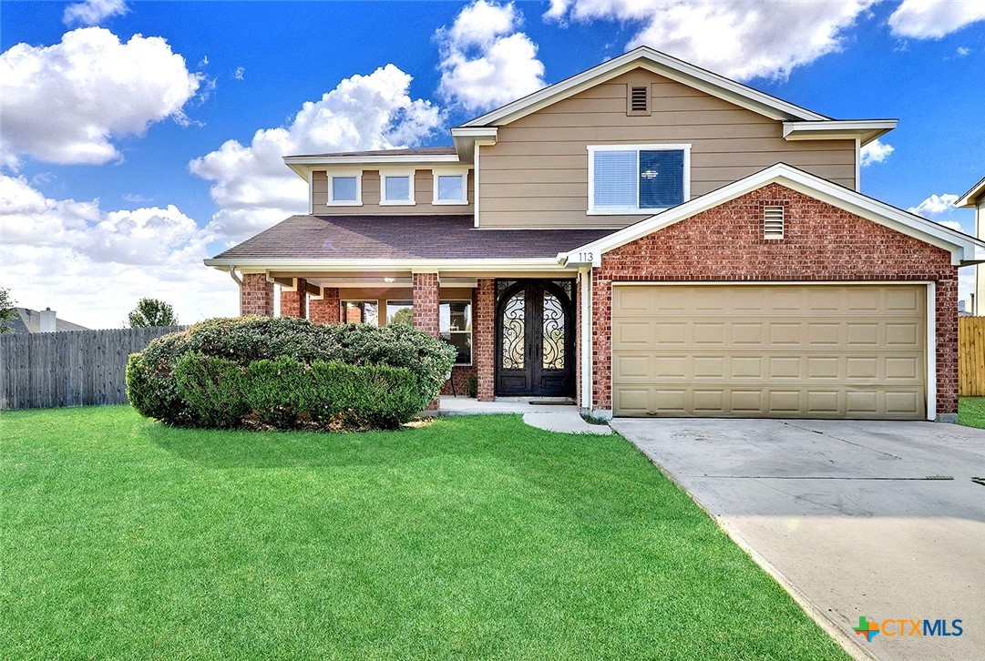 a front view of a house with a yard and garage