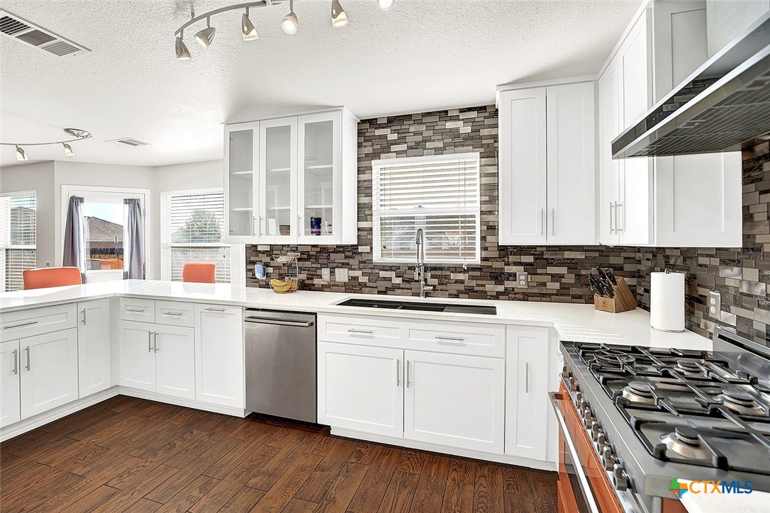 113 Endeavour Kyle, TX 78640 - Photo 14 of 38 a kitchen with stainless steel appliances a stove a sink and white cabinets