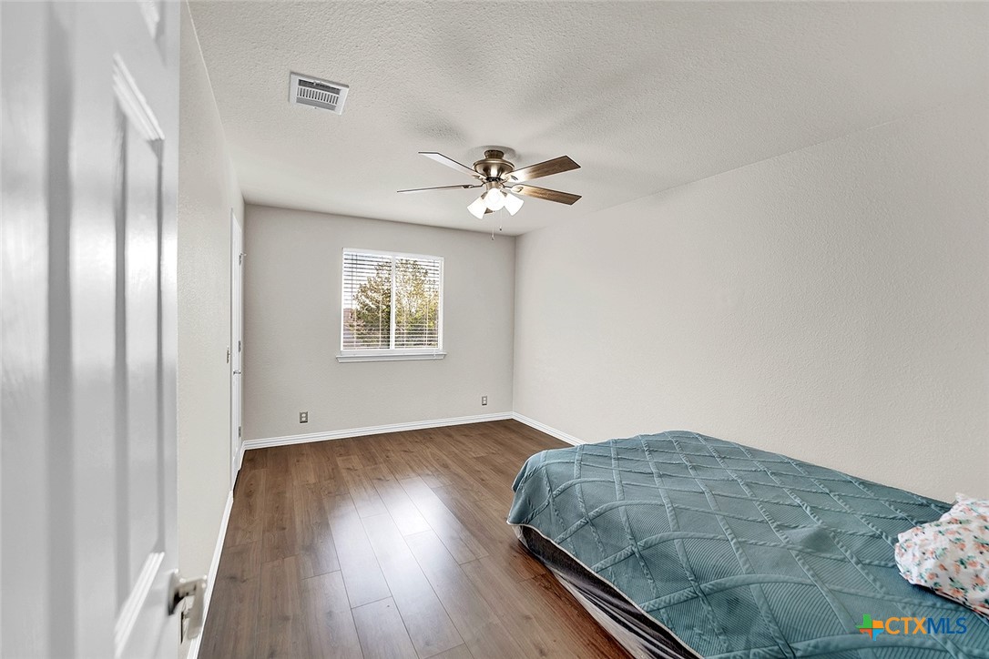 113 Endeavour Kyle, TX 78640 - Photo 24 of 38 an empty room with wooden floor chandelier fan and windows