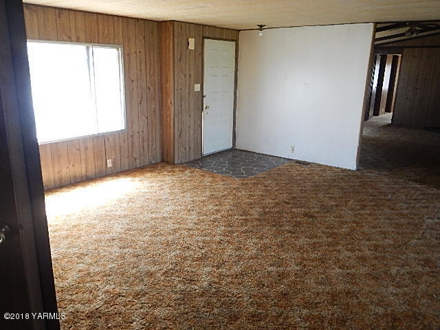 10331 Larue Road Toppenish, WA 98948 - Photo 8 of 13 a view of an empty room with wooden floor and a window