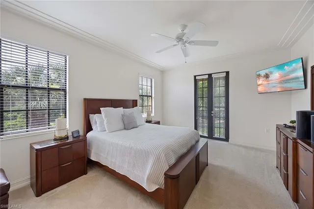 a bedroom with a large bed and a flat tv screen on dresser