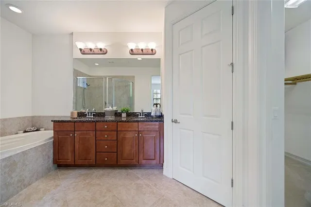 a spacious bathroom with a bathtub sink and mirror