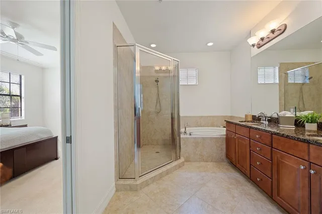 a spacious bathroom with a granite countertop sink a toilet a mirror and shower