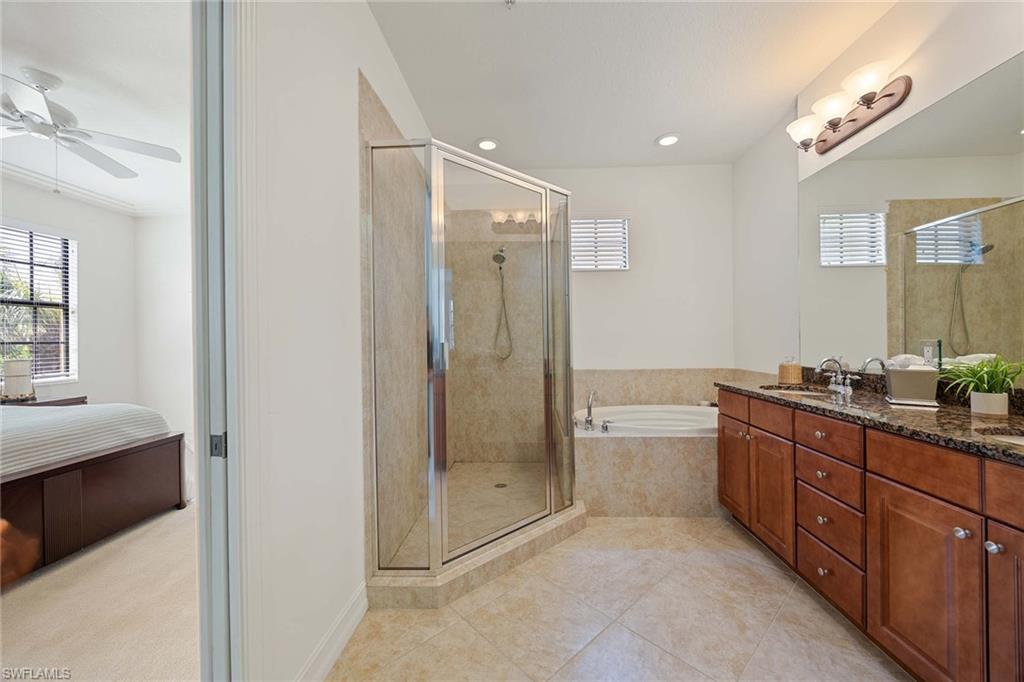 9134 Chula Vista Street, Unit 125 Naples, FL 34113 - Photo 16 of 44 a spacious bathroom with a granite countertop sink a toilet a mirror and shower