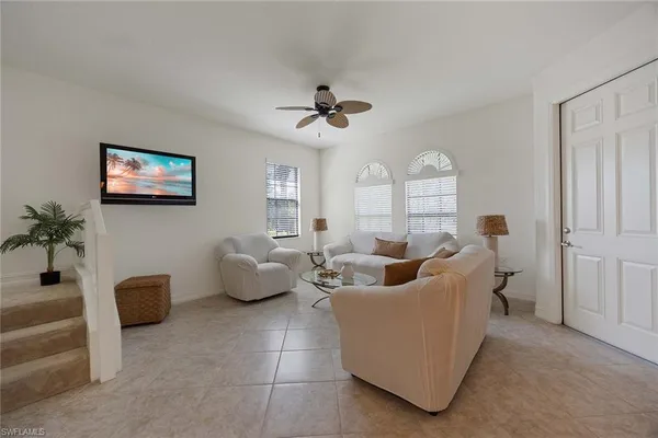 a living room with furniture and a ceiling fan