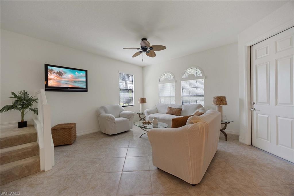 9134 Chula Vista Street, Unit 125 Naples, FL 34113 - Photo 3 of 44 a living room with furniture and a ceiling fan