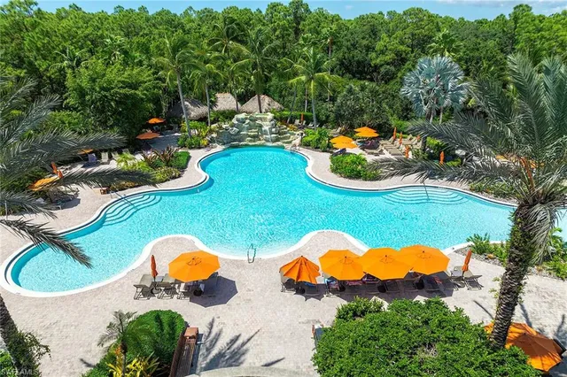 a front view of multi story residential apartment building with yard and sign board